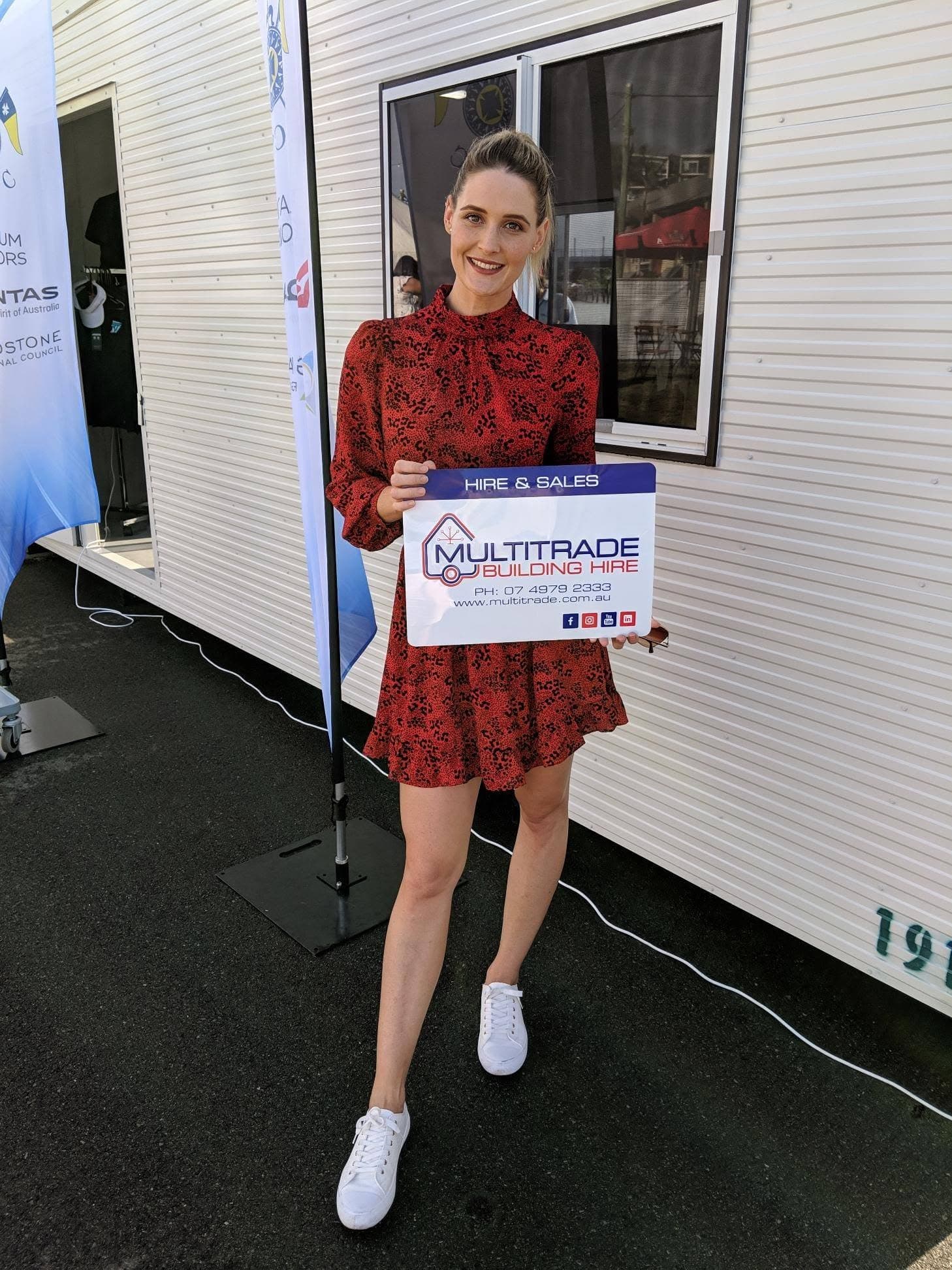 Harbour Festival representative holding the MBH sign outside a donated hire building