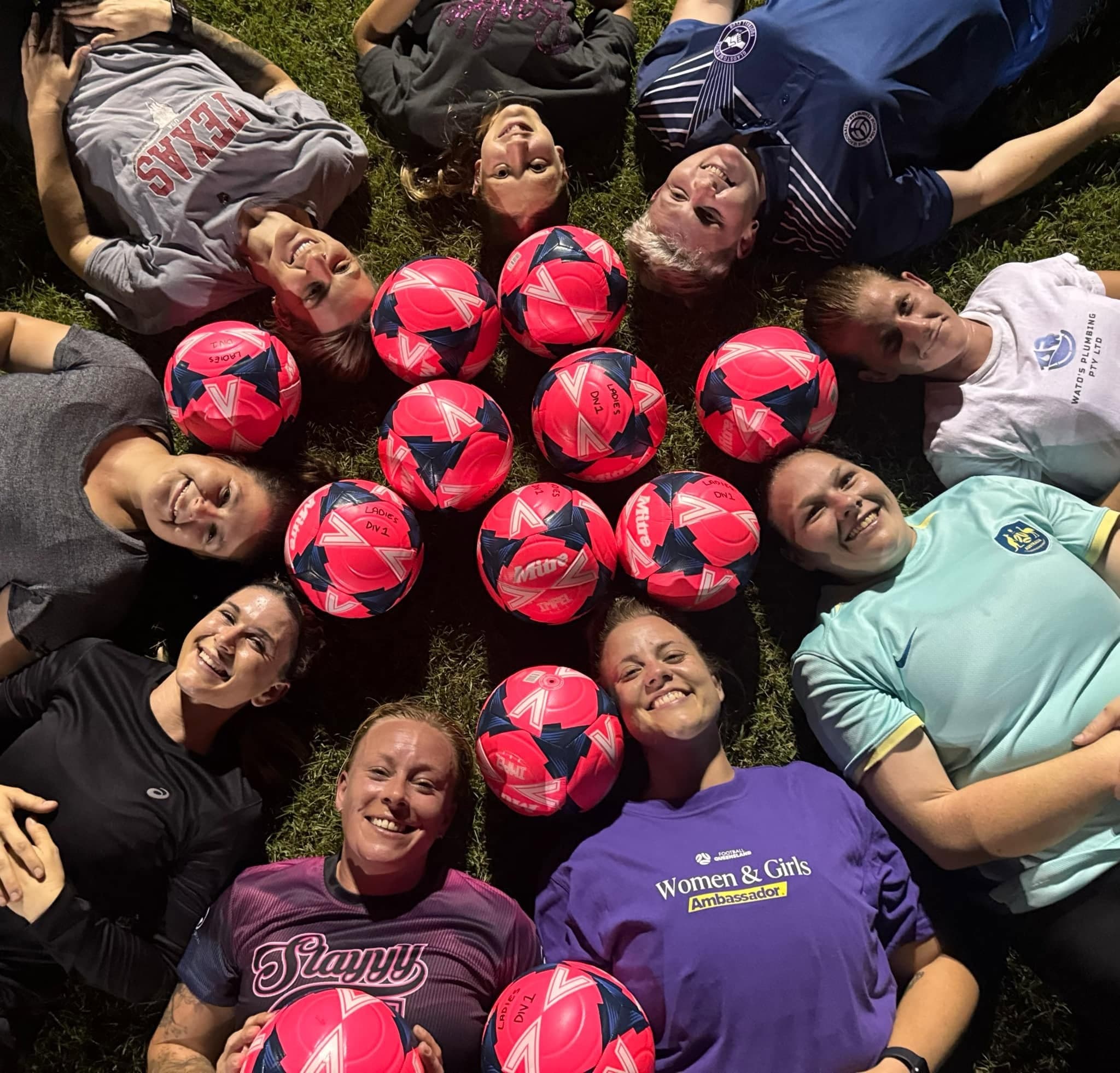United players gathered in a circle with pink footballs
