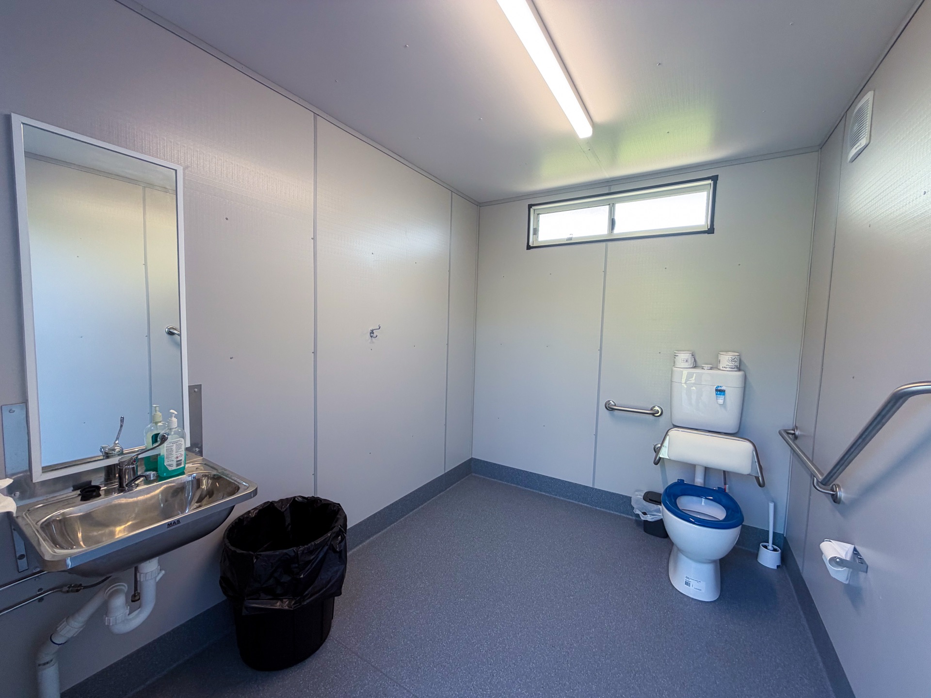 Interior — PWD accessible toilet with grab rails and S/S basin